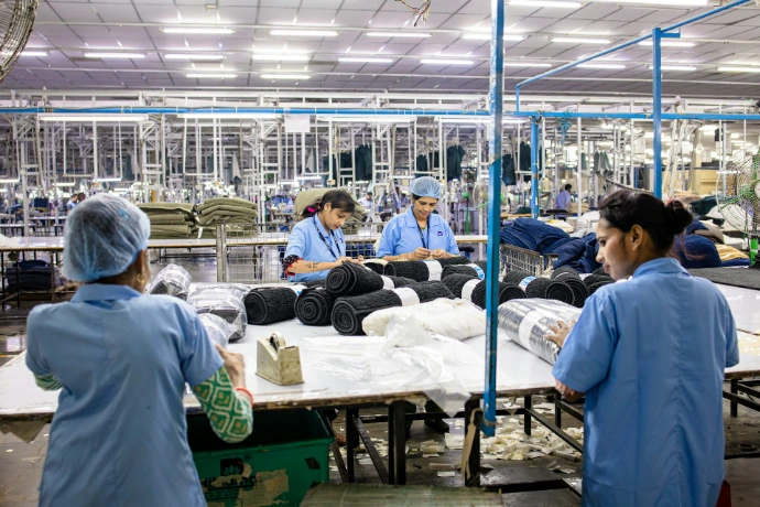 Workers are packaging textiles in a factory.